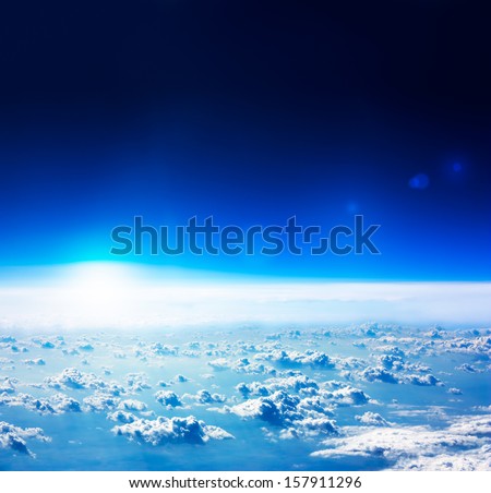 Earth View from Space. Dark Blue Sky with Rised Sun and Clouds.