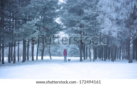 Woman with Small Dog Walking in Snowy Winter Park. Winter Lifestyle.