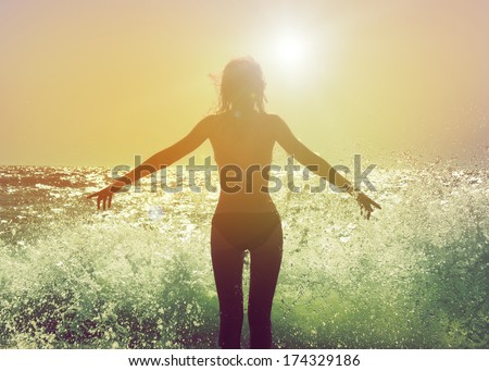 Beautiful Woman in Bikini Standing in the Sea Waves and Enjoying Sunshine with Open Arms