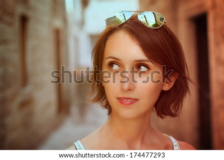 Toned Portrait of Trendy Young Woman with Bob Hairstyle in the Old Street. Filtered Photo with Shallow Depth of Field.