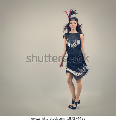 Full Length Portrait of a Retro Fashion Woman on Gray Background. 20s Vintage Style. Toned Photo. Copy Space.