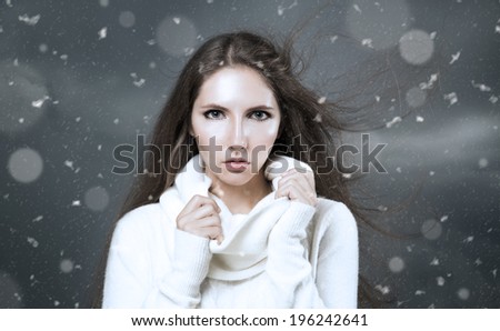 Outdoor Winter Portrait of Woman in White Cashmere Sweater. Dark Snow Storm Background.