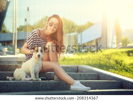 Trendy Hipster Girl with her Dog on Urban Background. Toned and Filtered Photo. Modern Youth Lifestyle Concept.