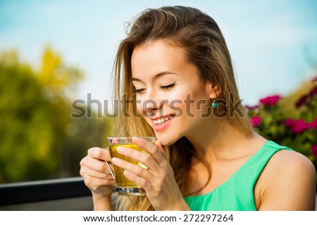 Young Happy Woman Drinking Green Tea Outdoors. Summer Background. Shallow Depth of Field. Healthy Nutrition Concept.