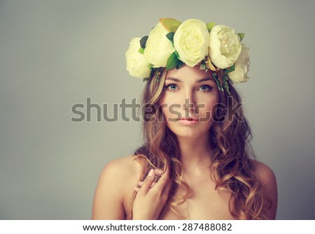 Portrait of a Young Woman with Wreath of Flowers on Gray Background. Natural Beauty Concept. Toned Photo with Copy Space.