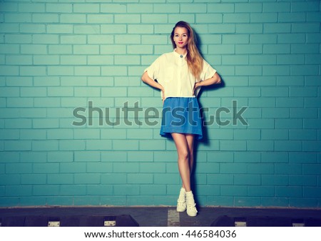 Trendy Hipster Girl at the Turquoise Brick Wall