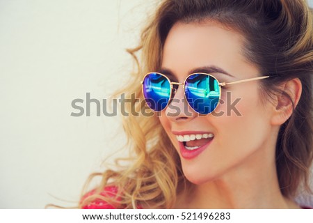 Close Up Portrait of Happy Fashion Woman in Sunglasses. Smiling Trendy Girl in Summer. Laughing Female. White Wall Background Copy Space. Not Isolated Toned Photo.