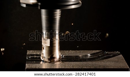 Milling cutter work with splinters flying off on a dark background