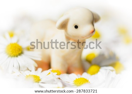 ceramic figurine sheep in floral swaddling clothes, bright edges, soft-focus view