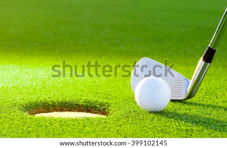golf ball from the hole with the putter on golf turf