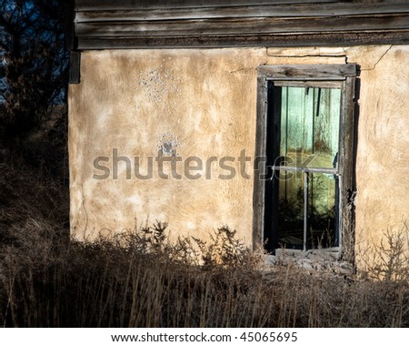 A green door shows through a broken window