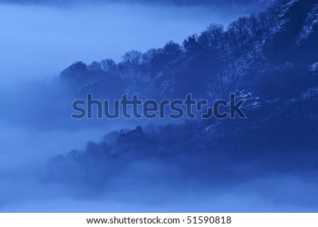 Monochromatic foggy landscape in blue hour