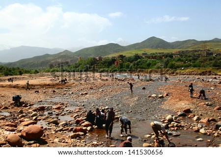 TNINE, MOROCCO-APRIL 29,: Man working in the Ourika river in the village or Tnine, Morocco on April 29, 2013. Tnine is a small village famous for its weekly market.