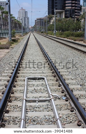 railroad tracks in big city during summertime