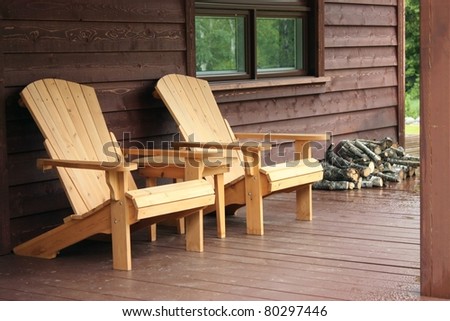 Adirondack wood chairs on a cabin porch - stock photo