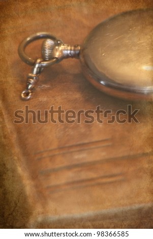 old leather book cover and pocket watch