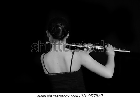 Gray-scale back view of a female flutist