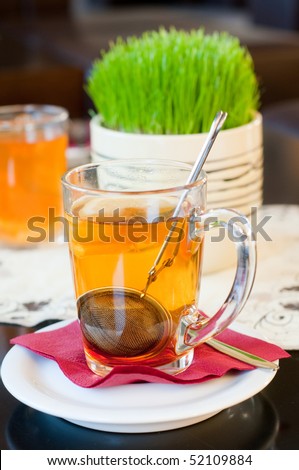 Shot of cup of tea with green grass on background