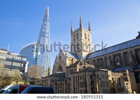 LONDON, UK - MARCH 29, 2014: Southwark Cathedral and Shard of glass. South bank walk of the river Thames. Contrast modern and old arhitecture