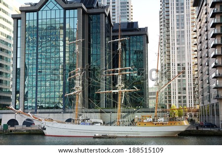 LONDON, CANARY WHARF UK - APRIL 13, 2014: - Modern glass architecture of Canary Wharf business aria, headquarters for banks, insurance, media and other world known companies. Historical boat