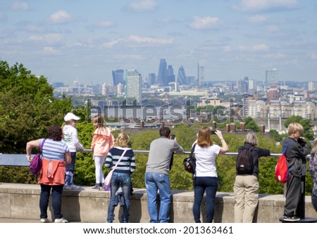 LONDON UK - MAY 15, 2014: Old English park south of London and view on Canary Wharf business district, tourists making pictures of great view
