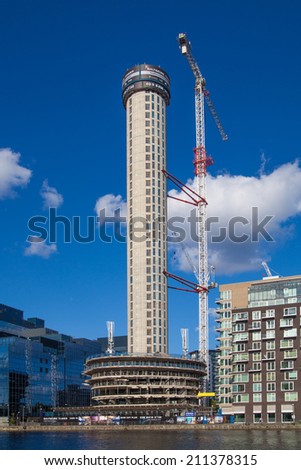 LONDON, UK - JULY 24, 2014 Building site with cranes in Canary Wharf aria Raising new tallest residential tower in 43 floors in the business office aria