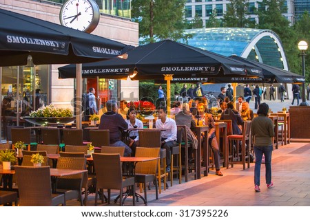 LONDON, UK - 7 SEPTEMBER, 2015: Canary Wharf night life. People sitting in local restaurant after long hours working day