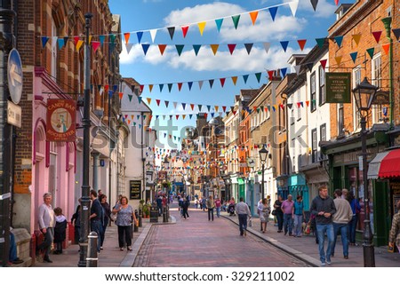 ROCHESTER, UK - MAY 16, 2015: Rochester high street at weekend. People walking through the street, passing cafes, restaurants and shops