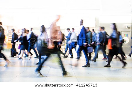 Blur of office workers walking pass the Canary Wharf tube station in early morning rush hours