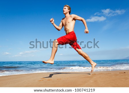 Physically fit man running on Beach