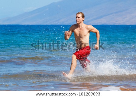 Physically fit man running on Beach in Hawaii