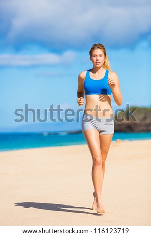 Running woman. Female runner jogging during outdoor workout on beach. Beautiful Fitness Model Outdoors.
