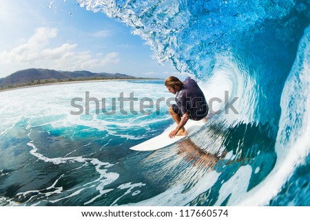 Surfer On Blue Ocean Wave In The Tube Getting Barreled