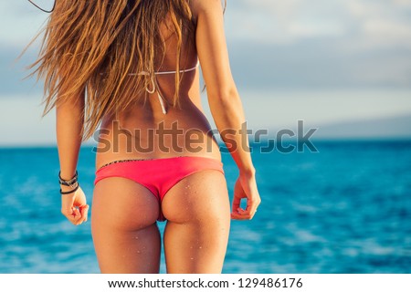 Beautiful young woman with surfboard in sexy bikini