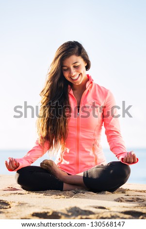 Young woman practicing morning meditation in nature at the beach
