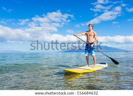 Attractive Young Man Stand Up Paddle Surfing In Hawaii, Beautiful Tropical Ocean, Active Beach Lifestyle