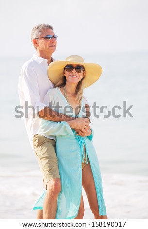 Happy Romantic Middle Aged Couple Enjoying Walk on the Beach, Vacation Retirement Concept