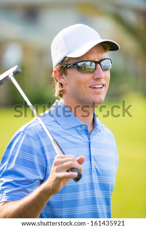 Athletic young man playing golf, Portrait of Golfer on Course with putter