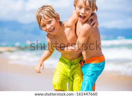 Two Young Boys Having Fun On Tropical Beach, Happy Best Friends Playing