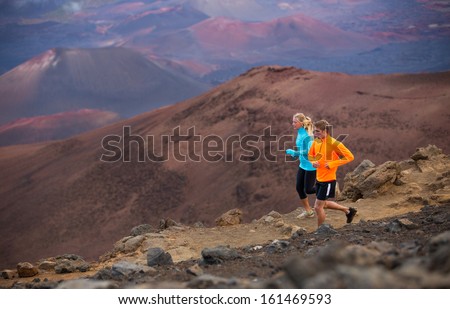 Fitness sport couple jogging outside, training together outdoors. Running on amazing trail at sunset, Dramatic beautiful volcano landscape