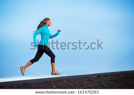 Athletic woman jogging outside training outdoors Running on road at sunset Athletic woman jogging outside training outdoors Running on road at sunset