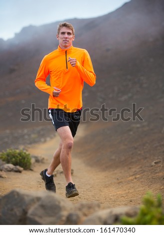 Athletic man jogging outside, training outdoors. Running on nature trail