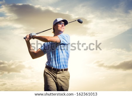 Golfer At Sunset, Man Swinging Golf Club With Dramatic Sunset Sky Backdrop