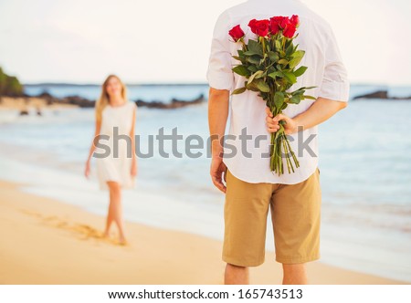 Young Couple in Love, Man holding surprise bouquet of roses for beautiful young woman, Romantic Date