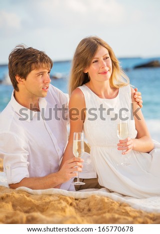 Man and Woman in love, Couple enjoying glass of champagne on tropical beach at sunset, Honeymoon concept