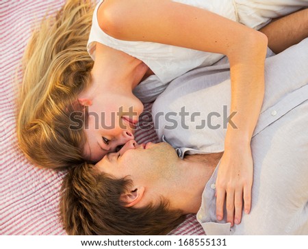 Romantic picnic in the park, loving couple cuddling on blanket outdoors on grass