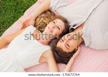 Romantic couple cuddling and flirting in park on blanket