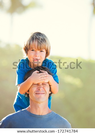 Happy father and son playing on tropical beach, carefree happy fun smiling lifestyle