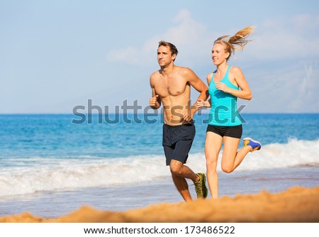 Couple running. Sport runners jogging on beach working out smiling happy. Fitness exercise concept.