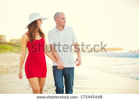 Happy couple in love, enjoying sunset walk on the beach